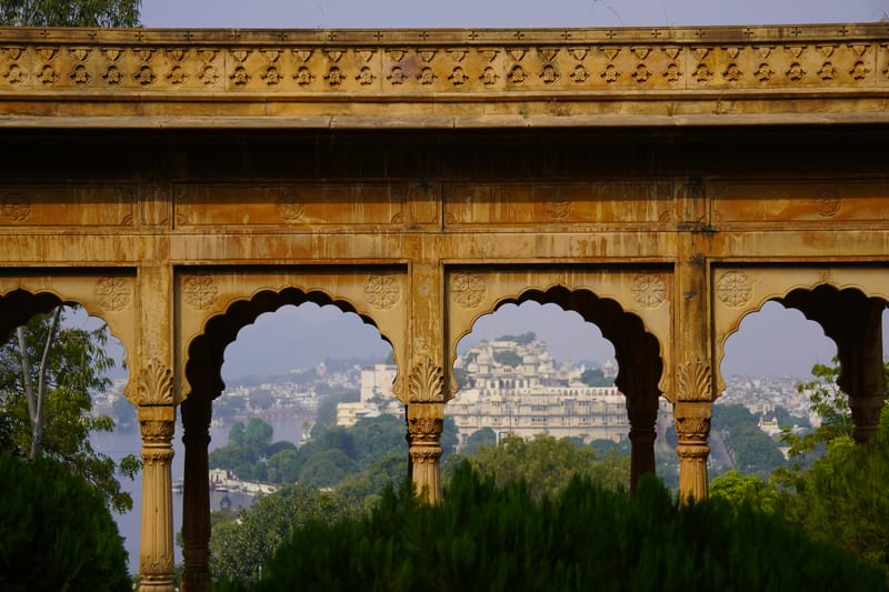 City Palace framed by an ornate historic archway with column carvings